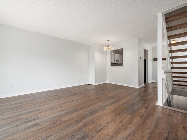 233 Malloy Ln Unit 78A, Blacklick, OH 43004 - empty room featuring a chandelier, dark wood-style flooring, baseboards, and a textured ceiling
