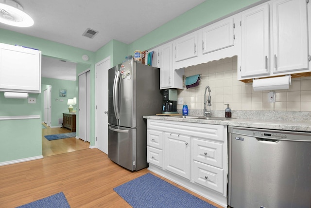 5885 Beechcroft Rd Unit 315, Columbus, OH 43229 - kitchen featuring stainless steel appliances, a sink, white cabinetry, light wood-style floors, and backsplash