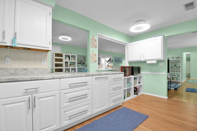 5885 Beechcroft Rd Unit 315, Columbus, OH 43229 - kitchen with white cabinets, light countertops, light wood finished floors, tasteful backsplash, and baseboards
