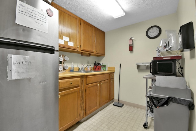 5885 Beechcroft Rd Unit 315, Columbus, OH 43229 - kitchen with a sink, light flooring, freestanding refrigerator, brown cabinets, and light countertops
