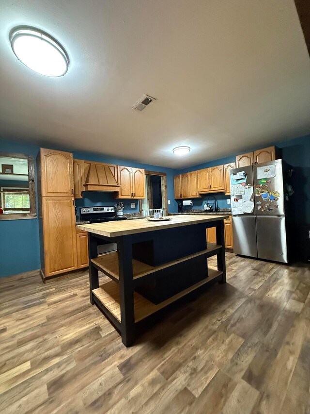 1775 Shoshoni Dr, Circleville, OH 43113 - kitchen featuring stainless steel appliances, custom exhaust hood, open shelves, light wood finished floors, and a kitchen island