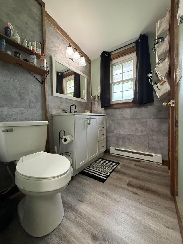 1775 Shoshoni Dr, Circleville, OH 43113 - bathroom with a baseboard radiator, wood finished floors, vanity, toilet, and tile walls