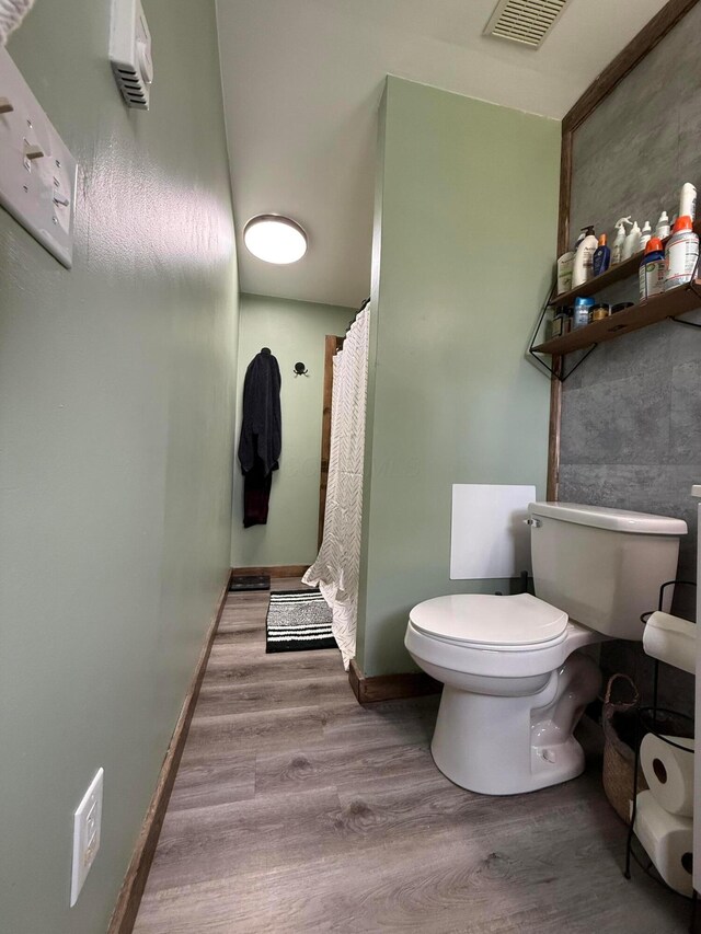 1775 Shoshoni Dr, Circleville, OH 43113 - bathroom featuring toilet, wood finished floors, baseboards, and curtained shower