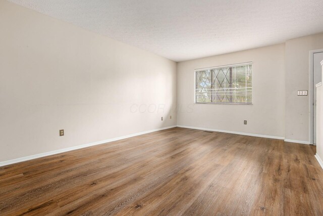 1955 Slaton Ct, Columbus, OH 43235 - unfurnished room featuring wood finished floors, baseboards, and a textured ceiling