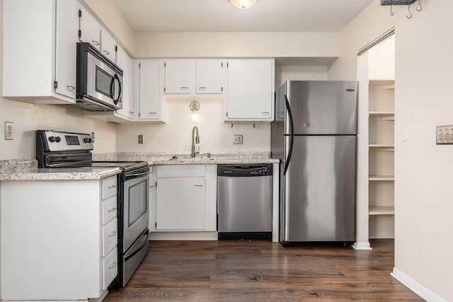 1955 Slaton Ct, Columbus, OH 43235 - kitchen featuring stainless steel appliances, dark wood finished floors, white cabinets, a sink, and baseboards