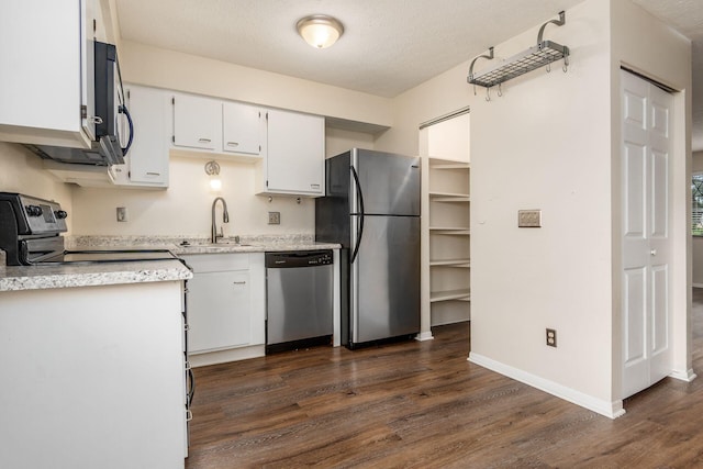 1955 Slaton Ct, Columbus, OH 43235 - kitchen with appliances with stainless steel finishes, dark wood-type flooring, a sink, white cabinetry, and baseboards