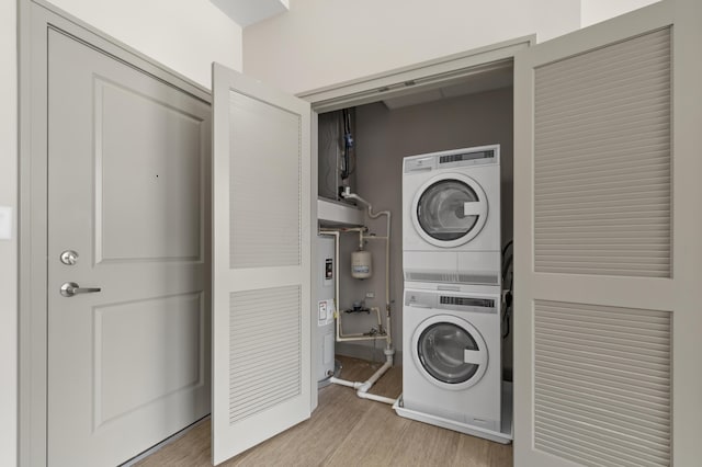 51 N High St # 806, Columbus, OH 43215 - laundry room featuring stacked washer and clothes dryer, light wood-type flooring, and electric water heater