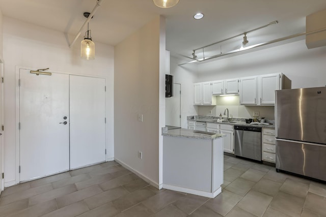 432 E Rich St Unit 4A, Columbus, OH 43215 - kitchen featuring stainless steel appliances, white cabinets, decorative light fixtures, light stone counters, and track lighting