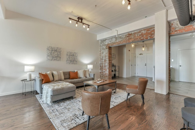432 E Rich St Unit 4A, Columbus, OH 43215 - living area featuring wood finished floors, brick wall, and track lighting