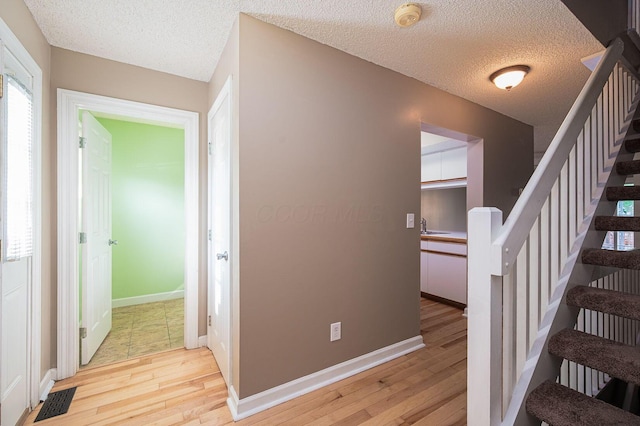 1845 Messner Dr Unit 57E, Hilliard, OH 43026 - stairs with hardwood / wood-style flooring, a textured ceiling, and baseboards