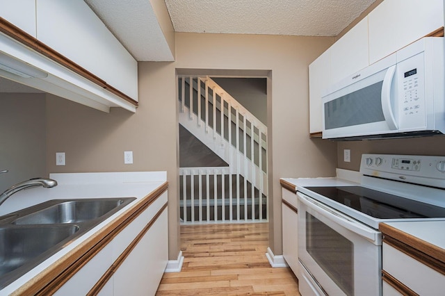 1845 Messner Dr Unit 57E, Hilliard, OH 43026 - kitchen with white appliances, a sink, light wood finished floors, white cabinetry, and light countertops