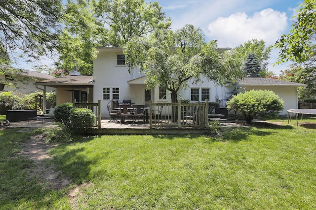 4286 Evansdale Rd, Columbus, OH 43214 - back of house featuring a trampoline, stucco siding, a deck, and a lawn