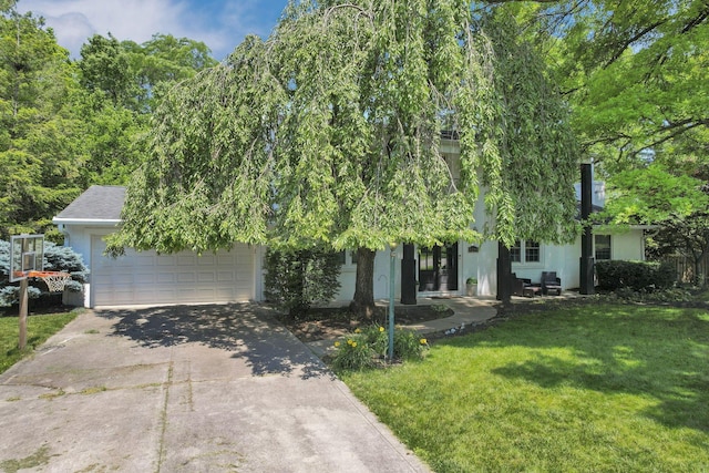 4286 Evansdale Rd, Columbus, OH 43214 - obstructed view of property with a front lawn, concrete driveway, stucco siding, and an attached garage