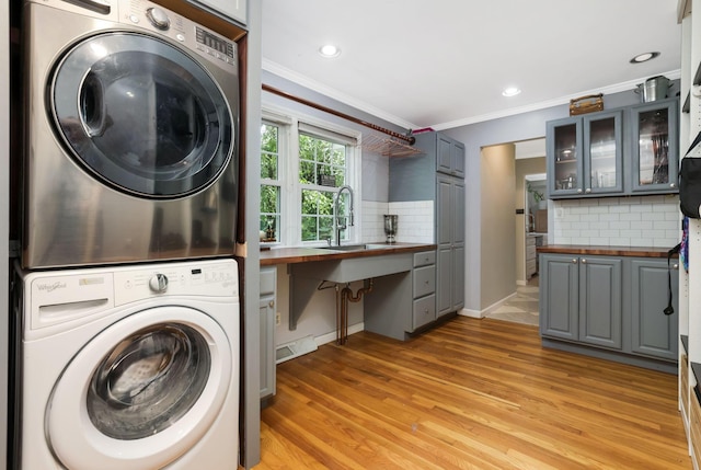 4286 Evansdale Rd, Columbus, OH 43214 - washroom with stacked washer and clothes dryer, crown molding, light wood-type flooring, and recessed lighting