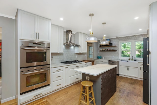 4286 Evansdale Rd, Columbus, OH 43214 - kitchen with stainless steel appliances, wall chimney exhaust hood, ornamental molding, backsplash, and a center island
