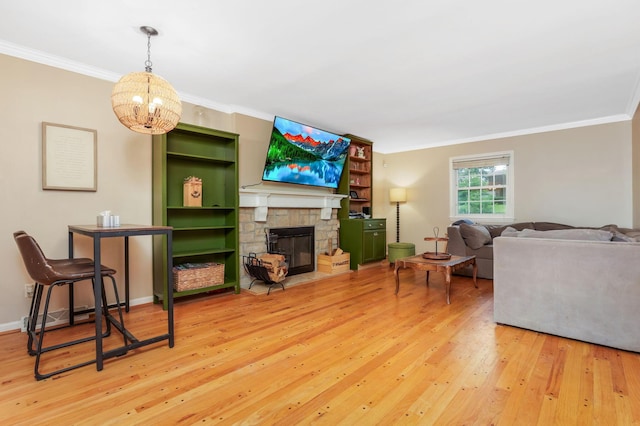 4286 Evansdale Rd, Columbus, OH 43214 - living area with ornamental molding, light wood-style flooring, a chandelier, and a stone fireplace