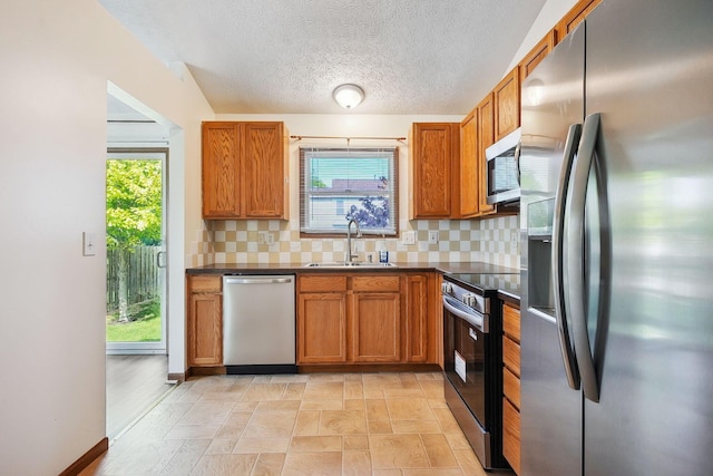 2147 Juneau Way, Grove City, OH 43123 - kitchen with stainless steel appliances, dark countertops, brown cabinets, backsplash, and a textured ceiling