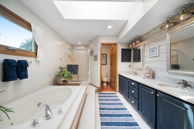 3040 Atoll Dr, Lewis Center, OH 43035 - bathroom featuring a skylight, a shower stall, double vanity, a tub with jets, and recessed lighting