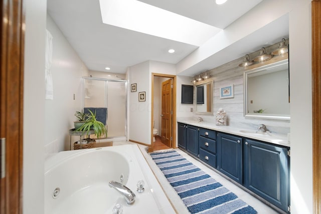 3040 Atoll Dr, Lewis Center, OH 43035 - bathroom featuring a shower stall, a whirlpool tub, double vanity, recessed lighting, and a skylight