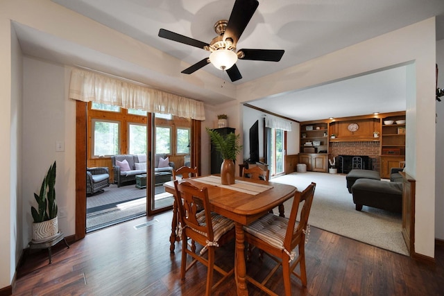 3040 Atoll Dr, Lewis Center, OH 43035 - dining space featuring dark wood-style floors, a ceiling fan, a brick fireplace, and built in features