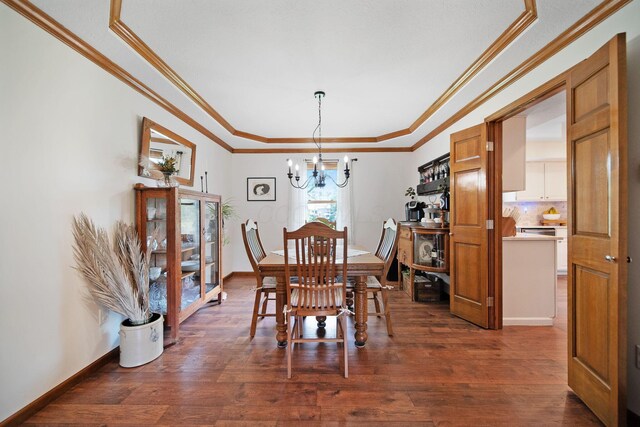 3040 Atoll Dr, Lewis Center, OH 43035 - dining space with a chandelier, dark wood-style flooring, a tray ceiling, and crown molding