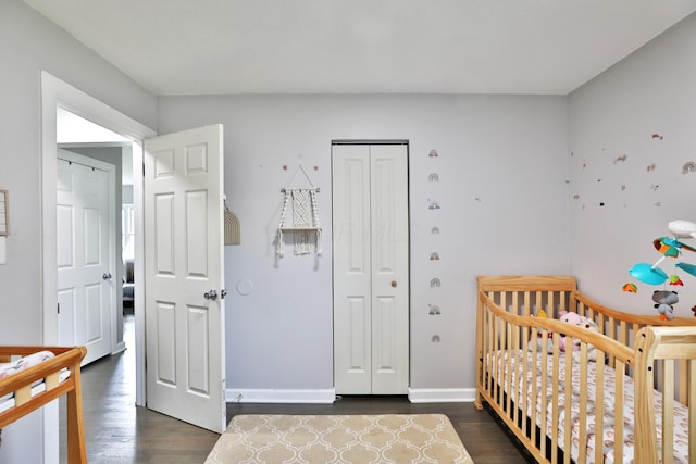 3216 Howey Rd, Columbus, OH 43224 - bedroom with dark wood-style floors, a closet, a nursery area, and baseboards