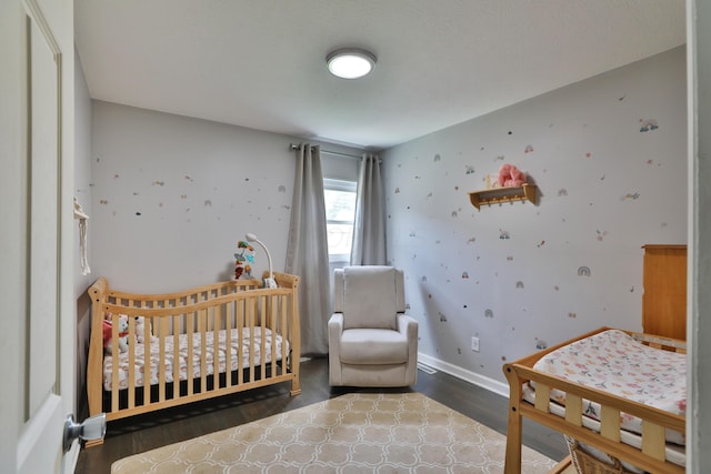 3216 Howey Rd, Columbus, OH 43224 - bedroom featuring wallpapered walls, wood finished floors, baseboards, and a crib