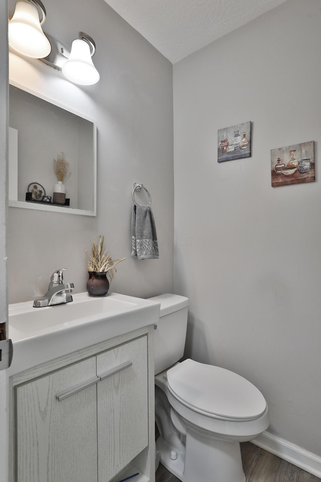 3216 Howey Rd, Columbus, OH 43224 - bathroom featuring toilet, vanity, wood finished floors, and baseboards