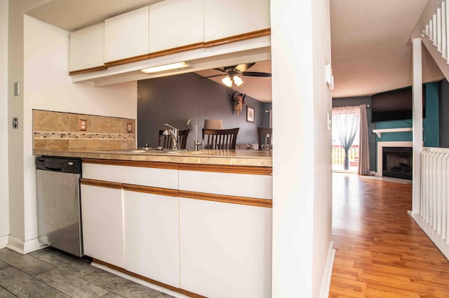 2043 Coleman Dr Unit 6F, Columbus, OH 43235 - kitchen featuring dishwasher, white cabinets, a ceiling fan, a fireplace with flush hearth, and light wood finished floors
