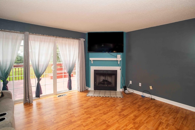 2043 Coleman Dr Unit 6F, Columbus, OH 43235 - unfurnished living room with wood finished floors, a fireplace with flush hearth, a textured ceiling, and baseboards