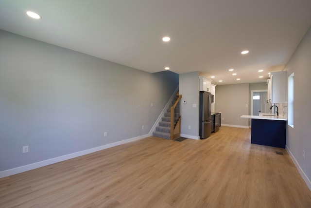 1275 Wager St, Columbus, OH 43206 - unfurnished living room featuring stairway, light wood-style flooring, and recessed lighting