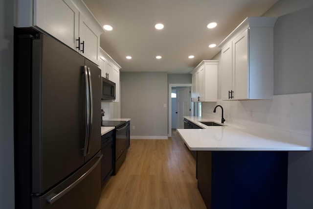 1275 Wager St, Columbus, OH 43206 - kitchen with freestanding refrigerator, light countertops, black electric range oven, light wood-type flooring, and tasteful backsplash