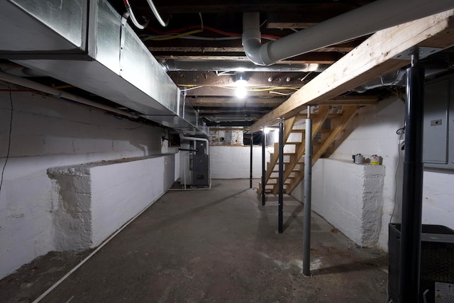 1275 Wager St, Columbus, OH 43206 - unfinished basement featuring heating unit, stairway, and concrete block wall