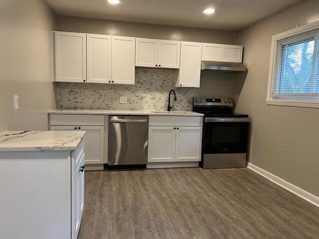 1416 Benson Dr, Columbus, OH 43227 - kitchen with stainless steel appliances, under cabinet range hood, decorative backsplash, white cabinetry, and recessed lighting