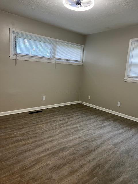 1416 Benson Dr, Columbus, OH 43227 - spare room with dark wood-type flooring and a textured ceiling