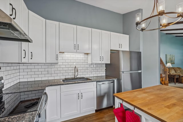 5452 Roche Ct W, Columbus, OH 43229 - kitchen with stainless steel appliances, ventilation hood, wood counters, a chandelier, and white cabinetry