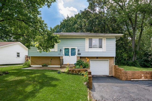 6563 Karl Rd, Columbus, OH 43229 - bi-level home featuring brick siding, a garage, asphalt driveway, and a front yard