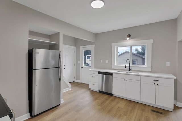 704 N Detroit St, Bellefontaine, OH 43311 - kitchen with stainless steel appliances, a sink, light wood-style flooring, and open shelves