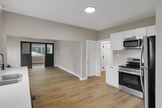 704 N Detroit St, Bellefontaine, OH 43311 - kitchen featuring stainless steel appliances, a sink, light wood-style flooring, and light countertops