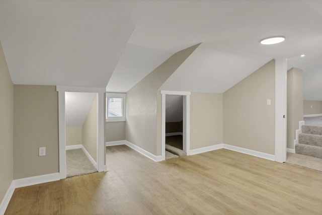 704 N Detroit St, Bellefontaine, OH 43311 - bonus room featuring light wood-style flooring, vaulted ceiling, stairway, and baseboards