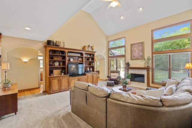 5839 Ketch St, Lewis Center, OH 43035 - living area featuring arched walkways, a ceiling fan, a tile fireplace, light colored carpet, and high vaulted ceiling