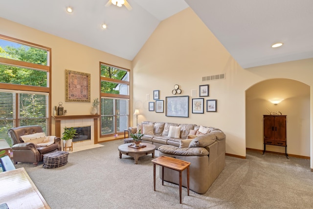 5839 Ketch St, Lewis Center, OH 43035 - carpeted living room featuring arched walkways, high vaulted ceiling, healthy amount of natural light, a tiled fireplace, and recessed lighting