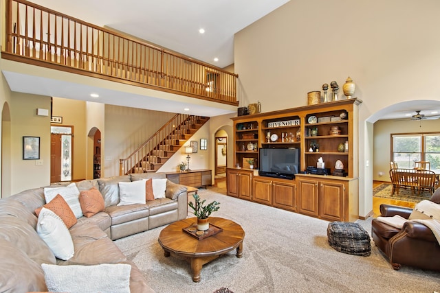 5839 Ketch St, Lewis Center, OH 43035 - carpeted living room featuring arched walkways, a high ceiling, stairway, a ceiling fan, and recessed lighting