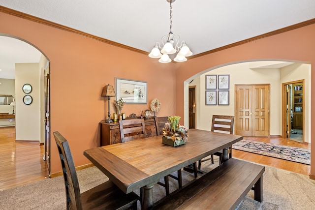 5839 Ketch St, Lewis Center, OH 43035 - dining space with arched walkways, a chandelier, crown molding, and light wood finished floors