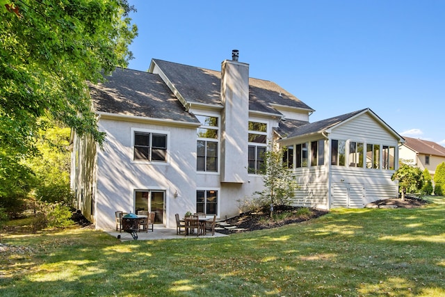 5839 Ketch St, Lewis Center, OH 43035 - rear view of house featuring a sunroom, a chimney, a patio area, and a lawn