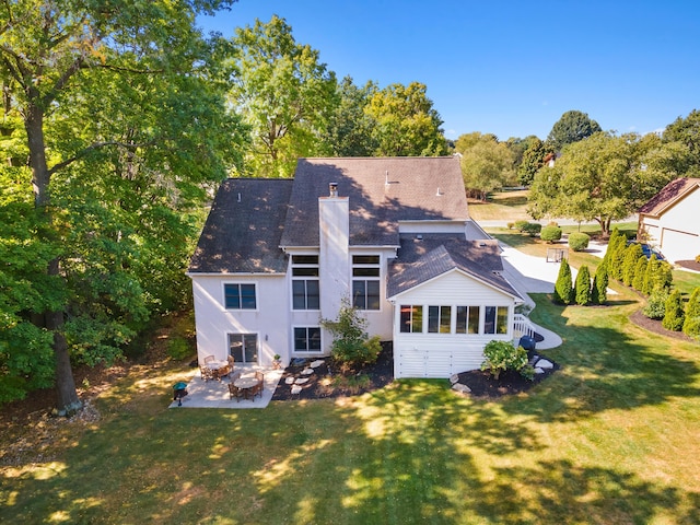 5839 Ketch St, Lewis Center, OH 43035 - back of property with a chimney, a patio area, a lawn, roof with shingles, and view of scattered trees