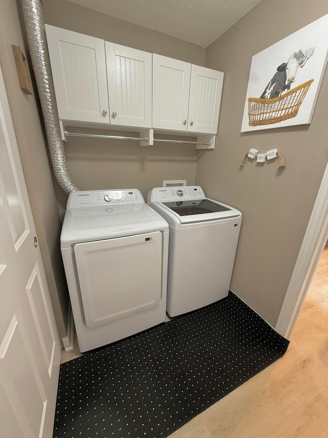 2210 Tournament Way, Grove City, OH 43123 - laundry room featuring washer and clothes dryer, cabinet space, and wood finished floors