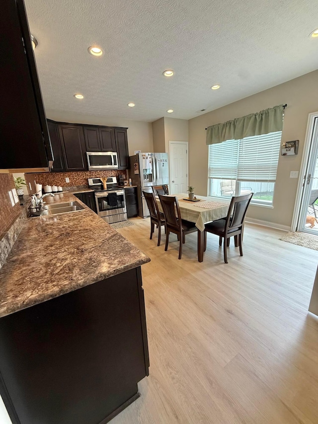 2210 Tournament Way, Grove City, OH 43123 - kitchen with stainless steel appliances, a sink, light wood-style flooring, tasteful backsplash, and a textured ceiling