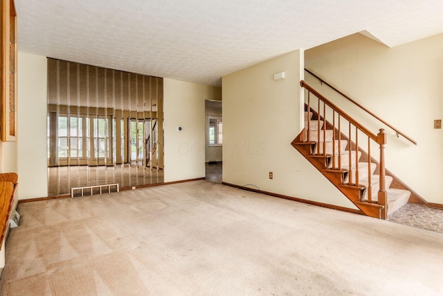 2655 Blendon Woods Blvd Unit 2644, Columbus, OH 43231 - unfurnished living room with carpet flooring, baseboards, stairs, and a textured ceiling