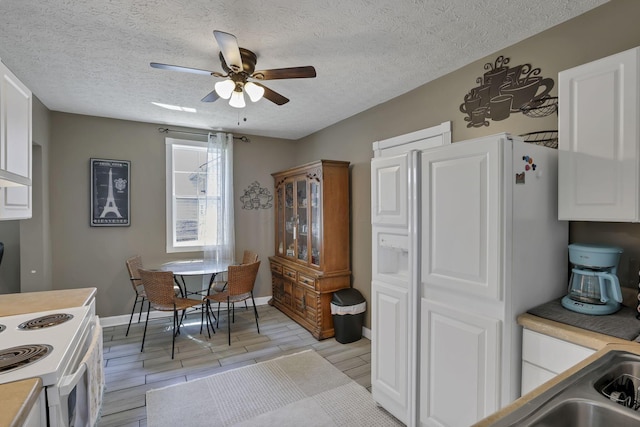 107 N Factory St, Baltimore, OH 43105 - kitchen with ceiling fan, white cabinetry, white appliances, light countertops, and a textured ceiling